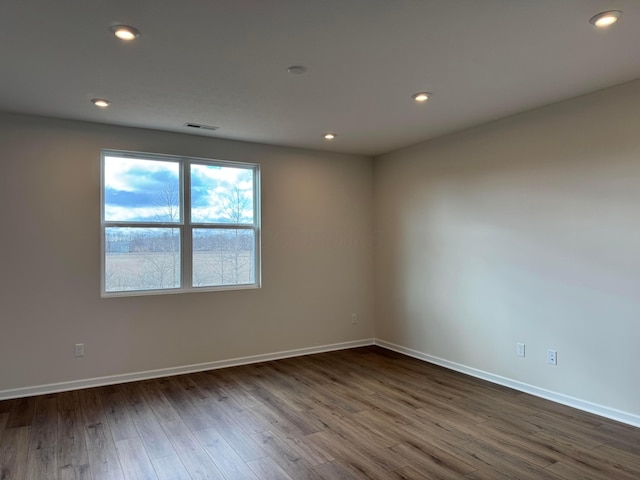 unfurnished room with dark wood-style floors, baseboards, and recessed lighting