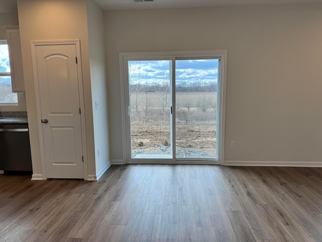 doorway to outside with visible vents, baseboards, and wood finished floors