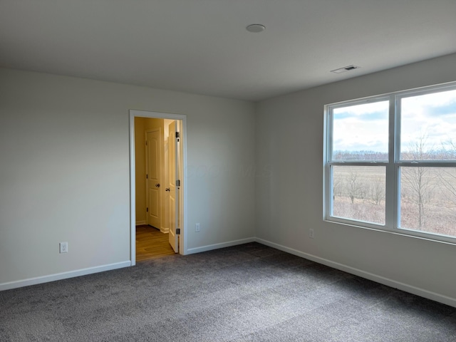 carpeted empty room featuring visible vents and baseboards