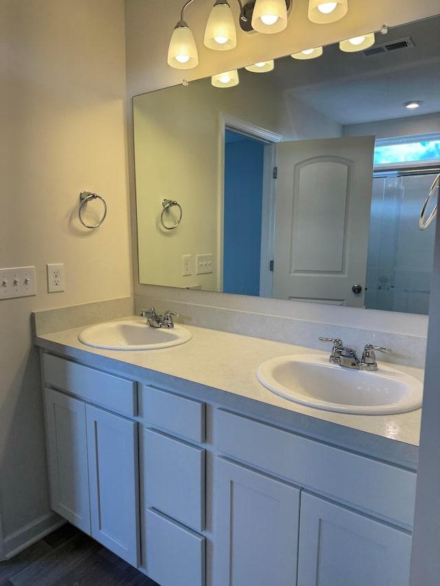 bathroom with double vanity, a sink, and visible vents