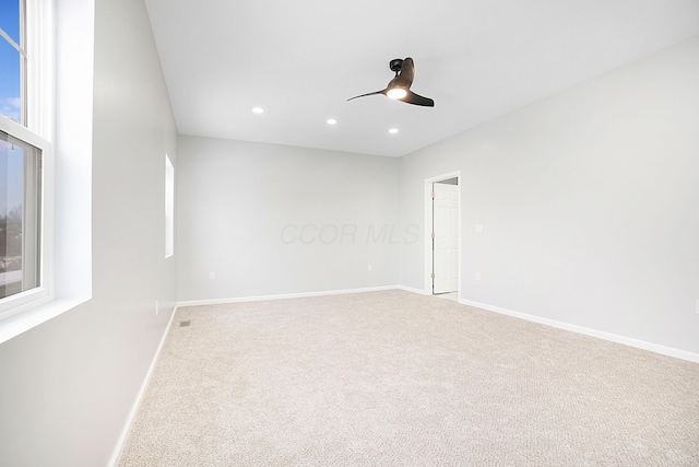 carpeted spare room featuring ceiling fan