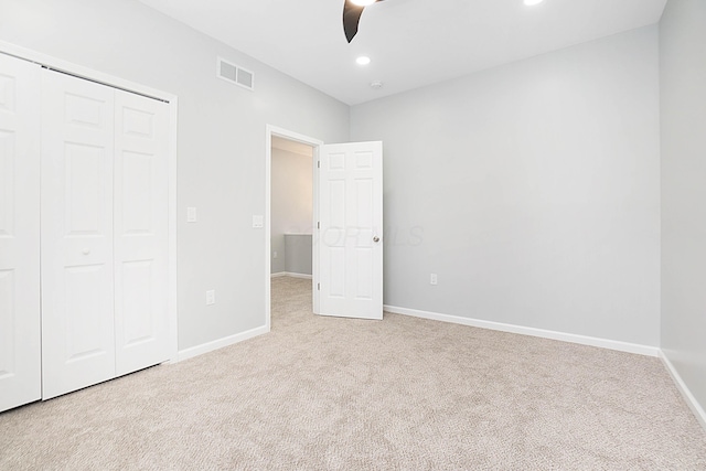 unfurnished bedroom featuring a closet, ceiling fan, and light colored carpet