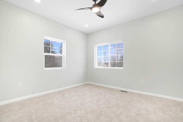 carpeted spare room with ceiling fan