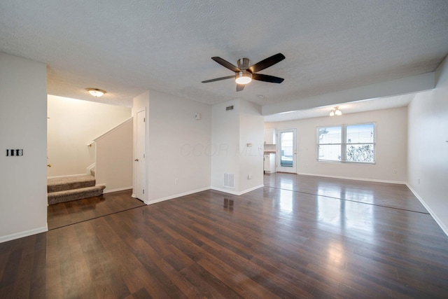 unfurnished living room with a textured ceiling, ceiling fan, and dark hardwood / wood-style flooring