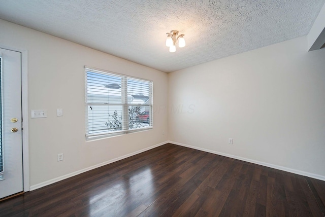 spare room with dark wood-type flooring and a textured ceiling