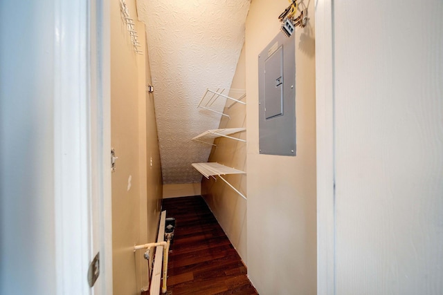 corridor featuring electric panel and dark wood-type flooring