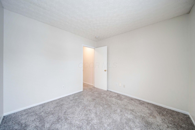 carpeted spare room with a textured ceiling