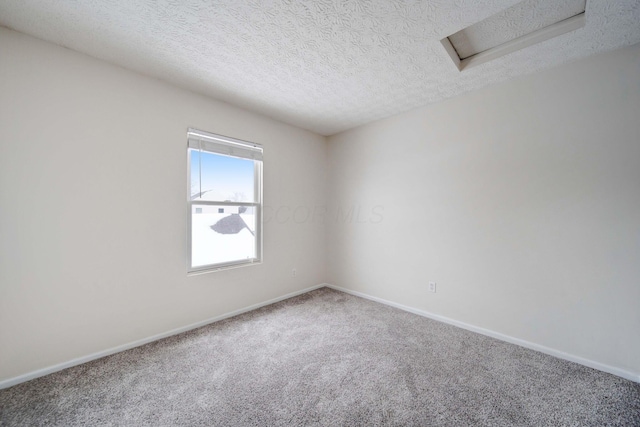 carpeted spare room with a textured ceiling