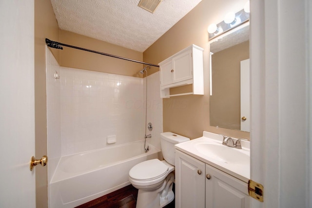 full bathroom with shower / washtub combination, toilet, vanity, hardwood / wood-style flooring, and a textured ceiling