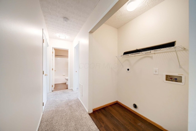 laundry room featuring electric dryer hookup, dark hardwood / wood-style flooring, a textured ceiling, and washer hookup