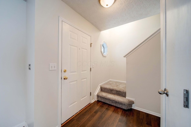 interior space featuring a textured ceiling and dark hardwood / wood-style floors