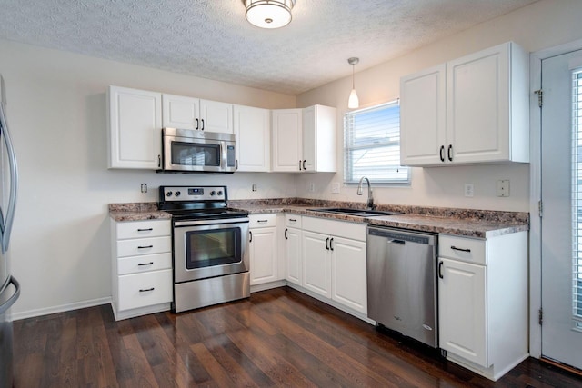 kitchen with sink, a textured ceiling, white cabinetry, pendant lighting, and appliances with stainless steel finishes