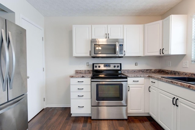 kitchen with white cabinetry, dark hardwood / wood-style floors, a textured ceiling, and appliances with stainless steel finishes