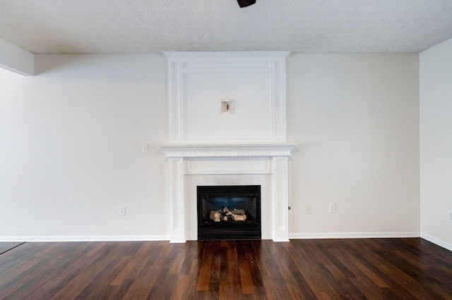 unfurnished living room featuring a large fireplace, dark wood-type flooring, and a textured ceiling