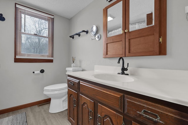 bathroom featuring hardwood / wood-style floors, vanity, a textured ceiling, and toilet