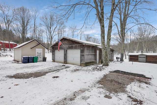 view of snow covered exterior featuring an outdoor structure and a garage