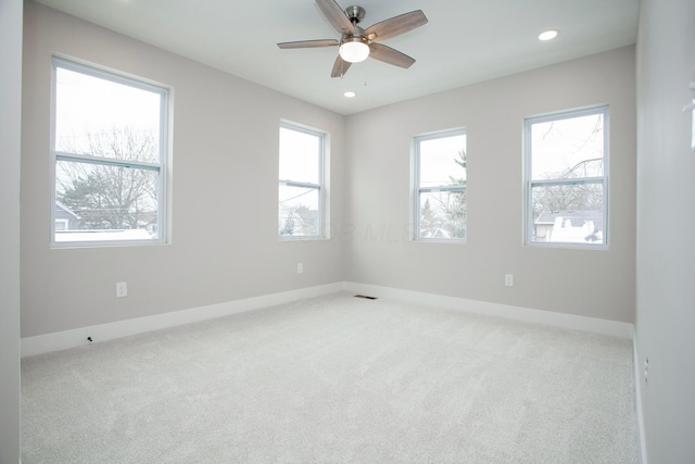 carpeted spare room featuring ceiling fan and a healthy amount of sunlight