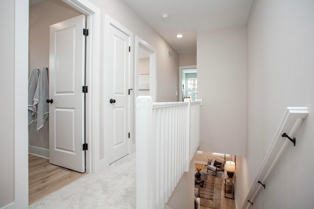 hallway with light colored carpet