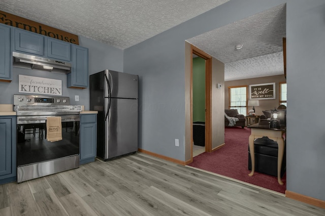 kitchen featuring a textured ceiling, blue cabinets, stainless steel appliances, and exhaust hood