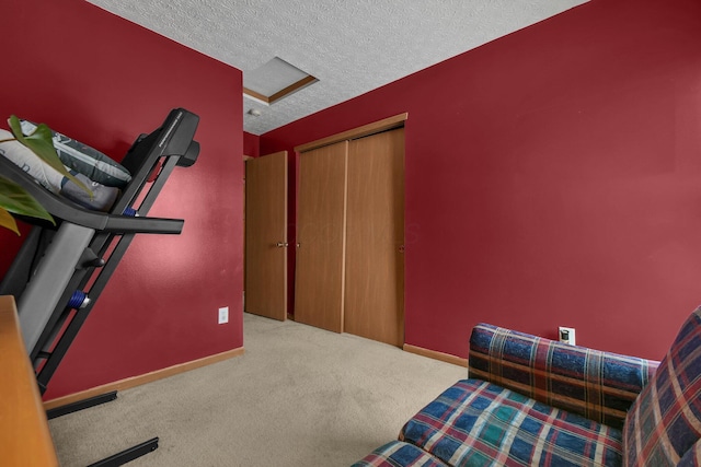 workout area with light colored carpet and a textured ceiling