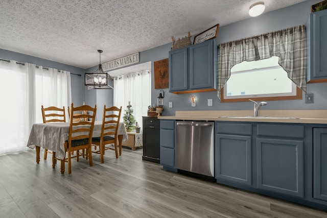 kitchen with decorative light fixtures, stainless steel dishwasher, blue cabinets, and sink