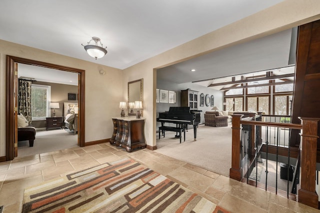 hallway featuring an upstairs landing, carpet flooring, baseboards, and stone tile floors