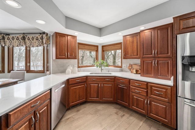 kitchen with stainless steel appliances, a sink, and light countertops