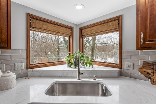 kitchen featuring marble finish floor, light stone counters, a sink, and recessed lighting