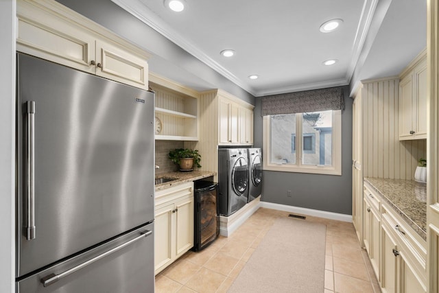 kitchen with light tile patterned floors, open shelves, cream cabinets, washer and dryer, and high end refrigerator