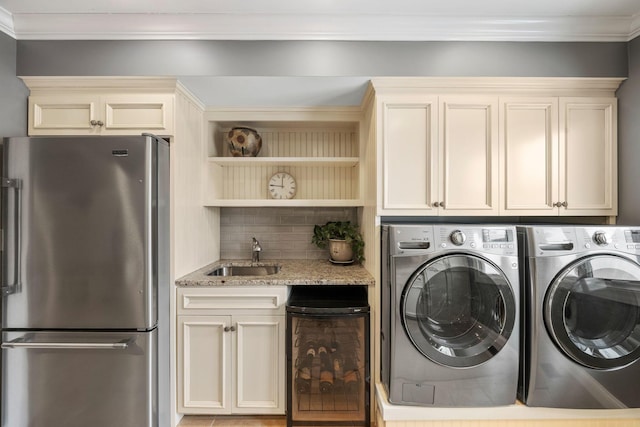 laundry area featuring crown molding, laundry area, a sink, and washer and dryer