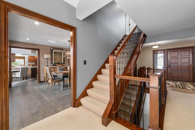 stairs with baseboards, wood finished floors, and recessed lighting