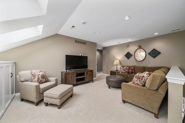 living area featuring light carpet, lofted ceiling with skylight, and visible vents