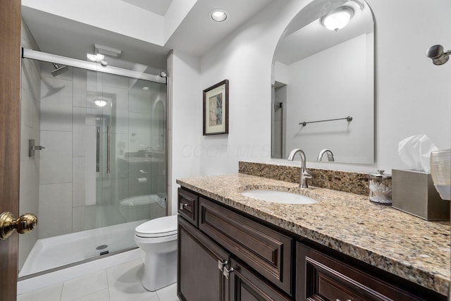 bathroom with vanity, a shower stall, toilet, and tile patterned floors