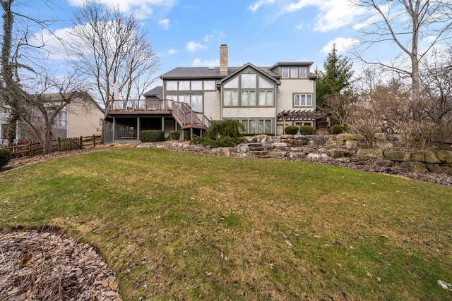 back of house featuring a chimney, a lawn, fence, a wooden deck, and stairs