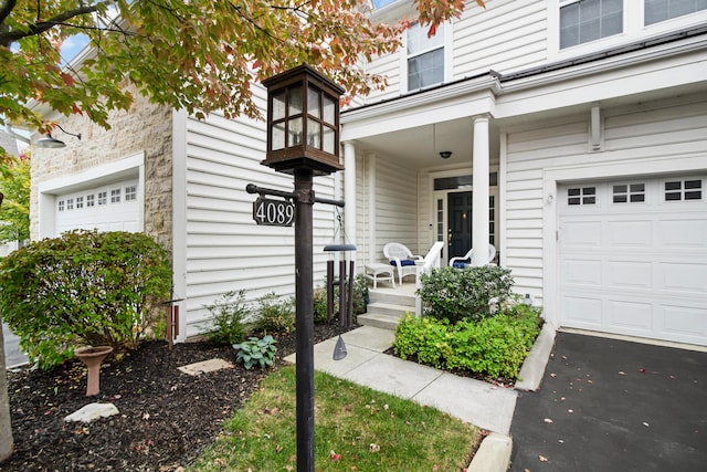 entrance to property with covered porch and a garage