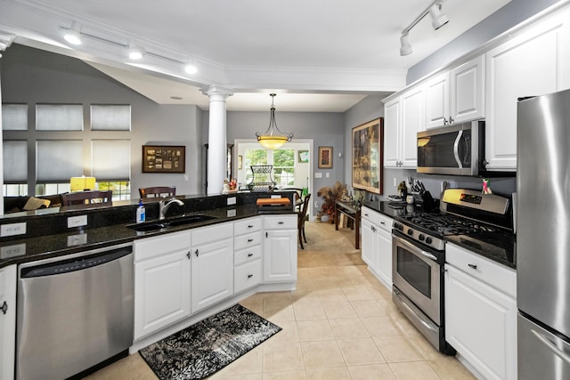 kitchen featuring decorative columns, white cabinetry, sink, and stainless steel appliances