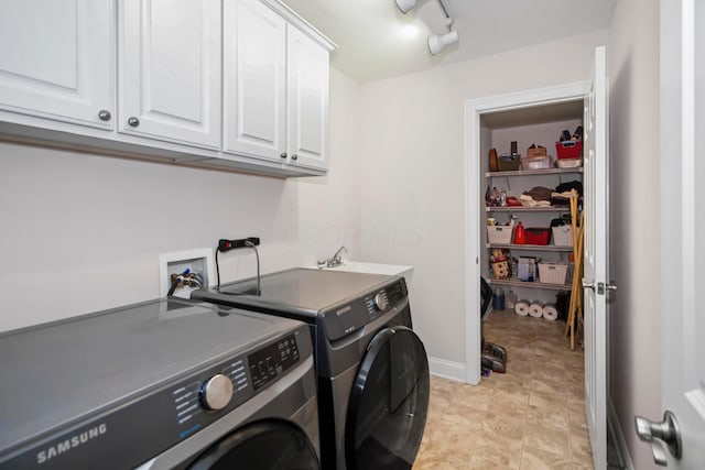 clothes washing area featuring cabinets, independent washer and dryer, and sink