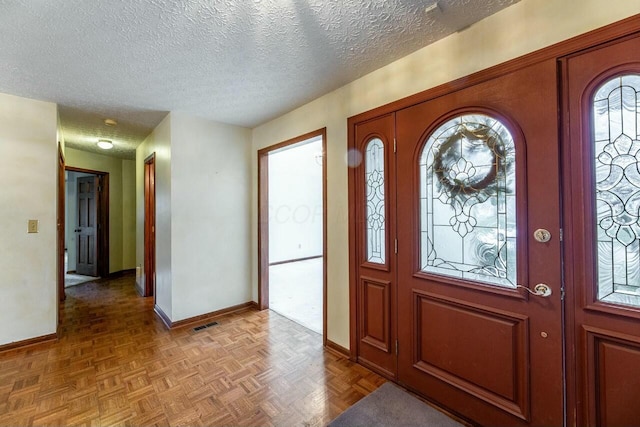 foyer featuring parquet flooring and a textured ceiling