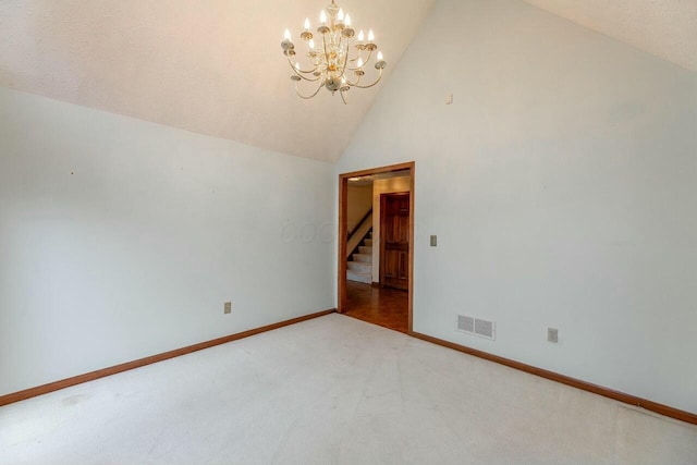 carpeted empty room with an inviting chandelier and vaulted ceiling