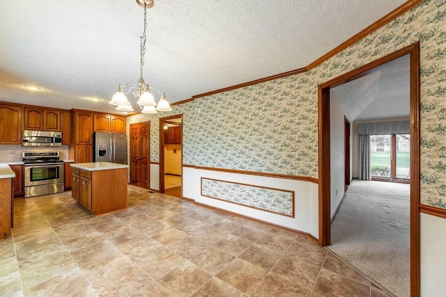 kitchen featuring stainless steel appliances, light colored carpet, pendant lighting, an inviting chandelier, and a center island