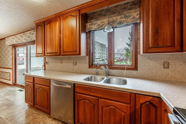 kitchen featuring sink, stainless steel dishwasher, backsplash, pendant lighting, and range