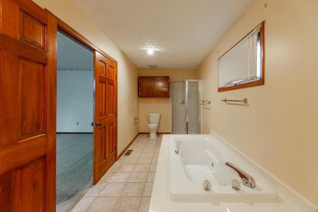 bathroom featuring plus walk in shower, a textured ceiling, and toilet