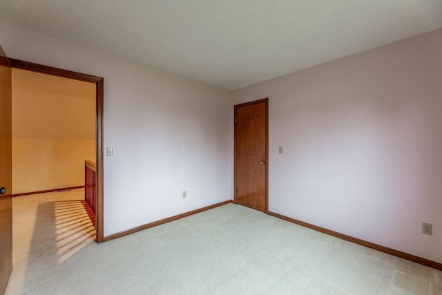 spare room featuring carpet flooring and a textured ceiling