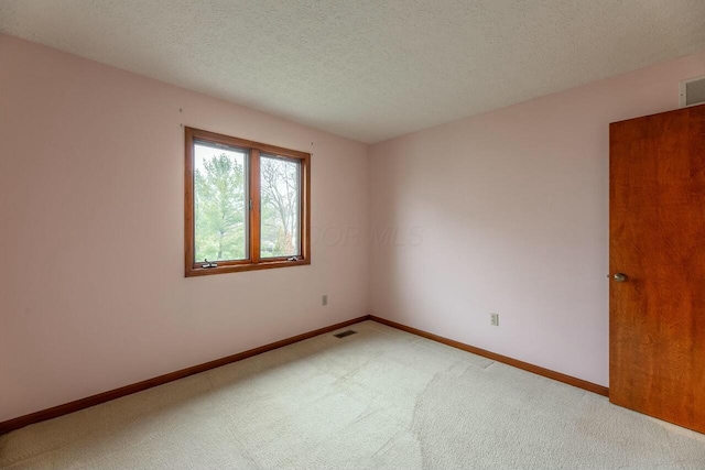 empty room with carpet flooring and a textured ceiling