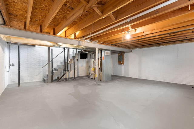 basement with electric panel and brick wall