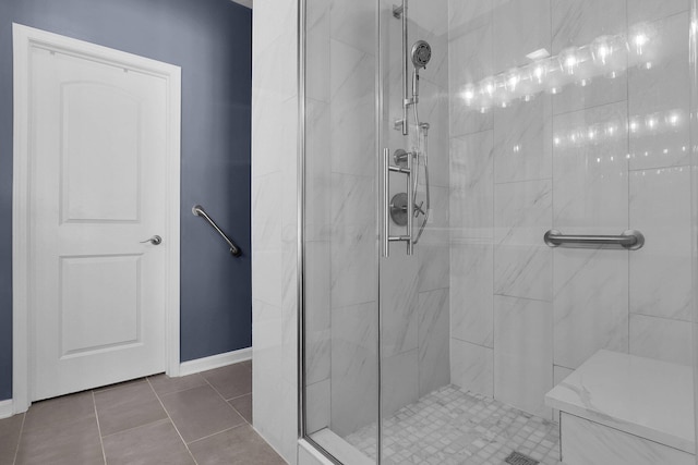 bathroom with a shower with door and tile patterned floors