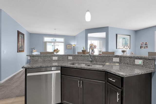 kitchen with light carpet, dark stone counters, sink, pendant lighting, and dishwasher