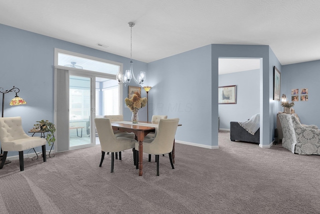 carpeted dining area featuring a notable chandelier and a textured ceiling