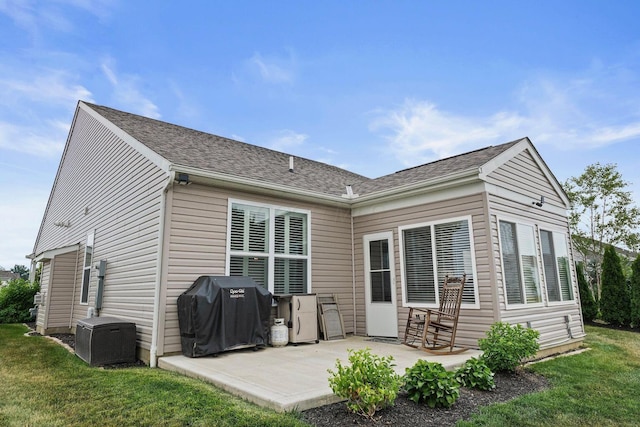 rear view of property with a yard and a patio area