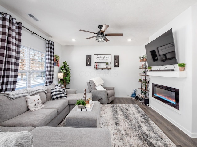 living room with ceiling fan and dark hardwood / wood-style flooring